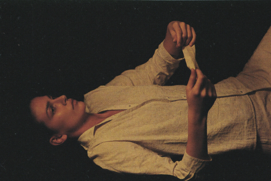 A woman awake in the dark turning her wrist to check a band she is wearing