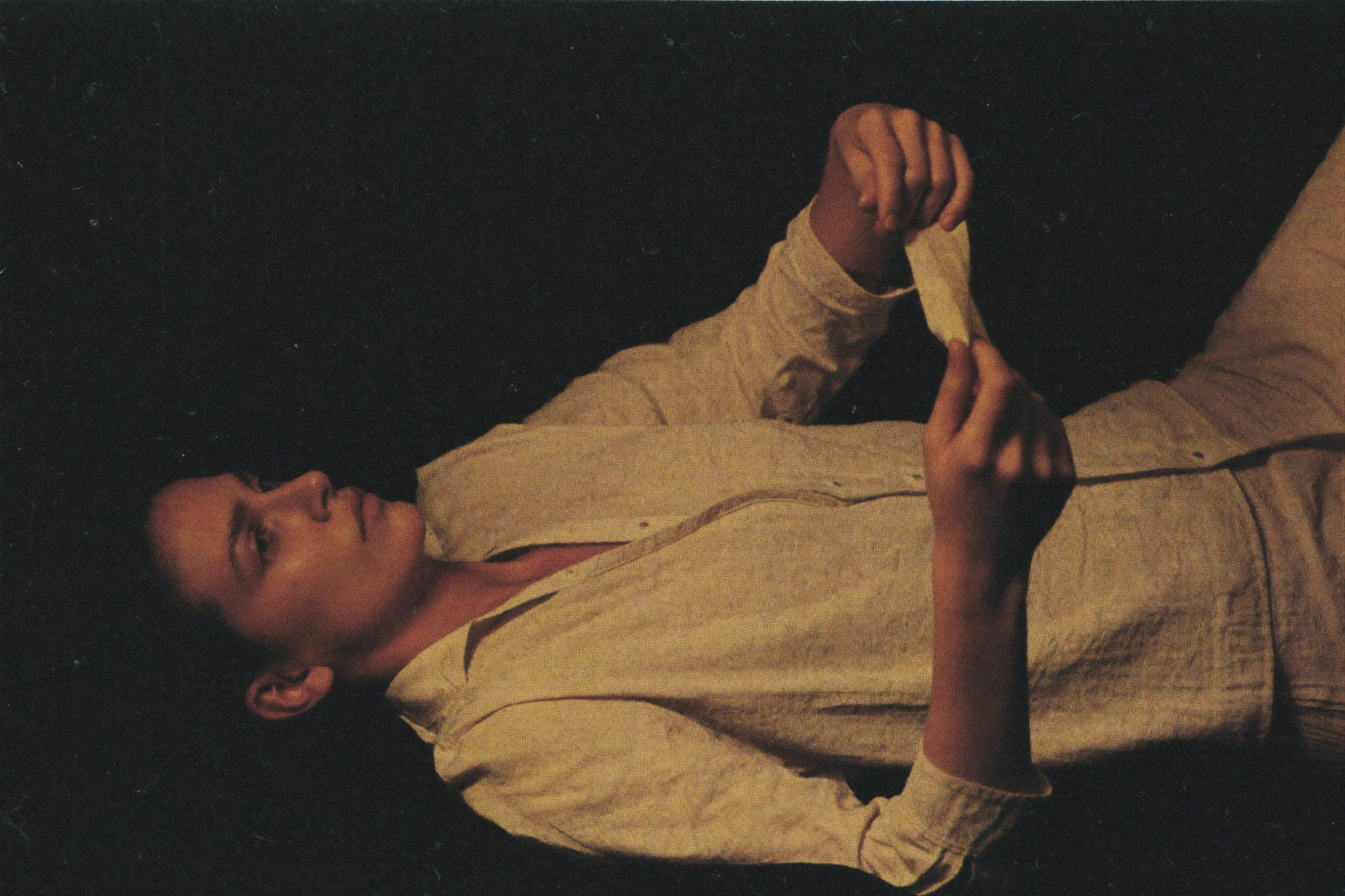 A woman awake in the dark turning her wrist to check a band she is wearing